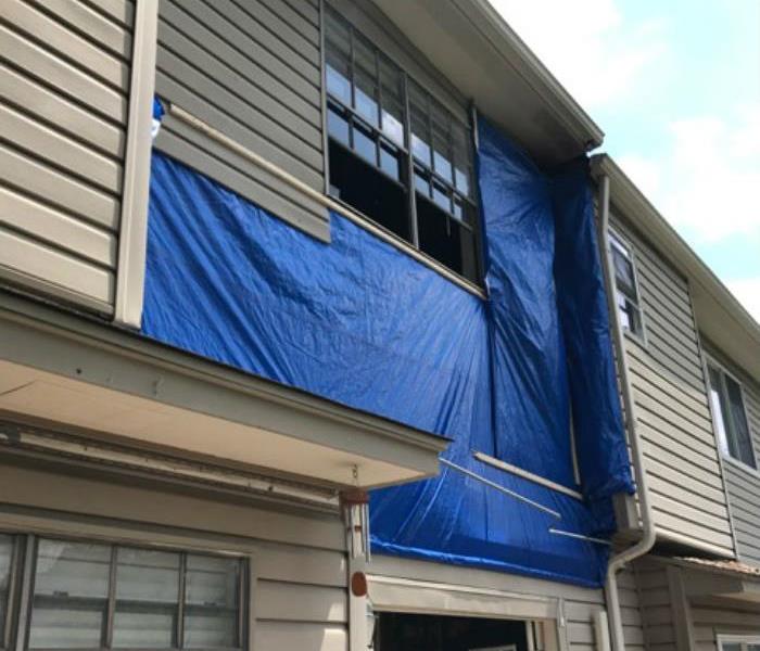 Dallas apartment wall covered with tarp after fire damage